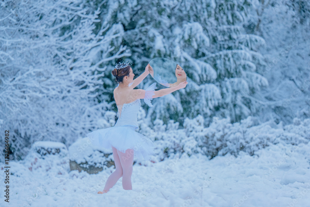 Ballerina in white tutu and tiara dances with mirror in snowy winter forest. WA, USA Ballerina in white tutu and tiara dances with mirror in snowy winter forest. WA, USA