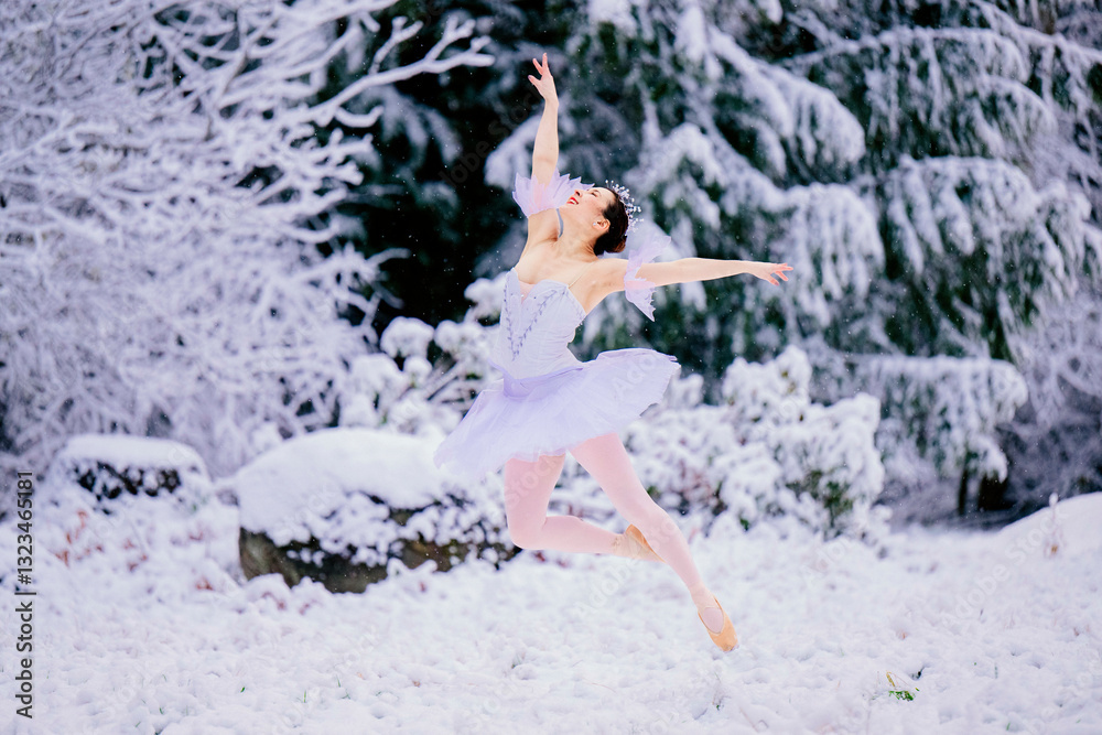Ballerina performing a graceful leap in a snowy winter forest scene. WA, USA Ballerina performing a graceful leap in a snowy winter forest scene. WA, USA