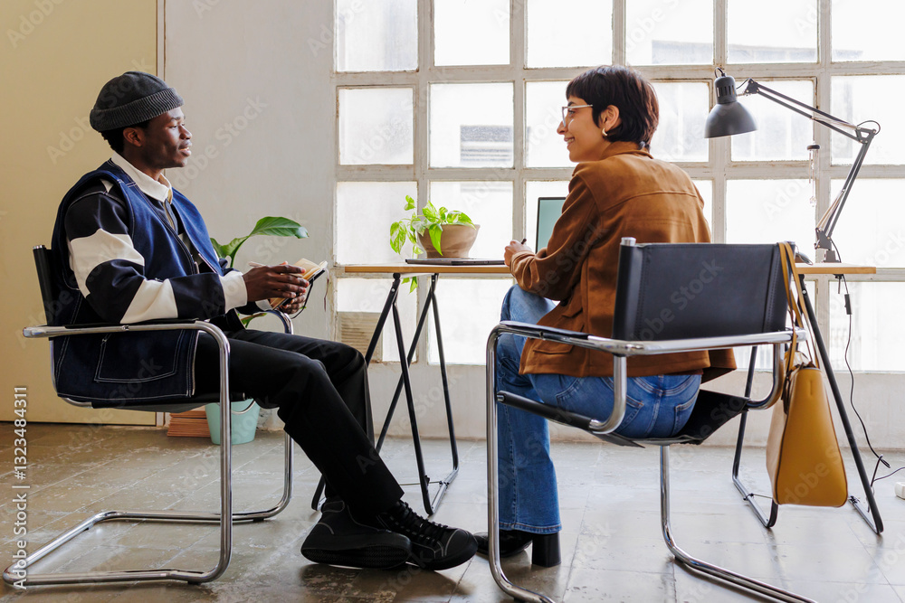 Two professionals collaborating on project in modern office space Two professionals collaborating on project in modern office space