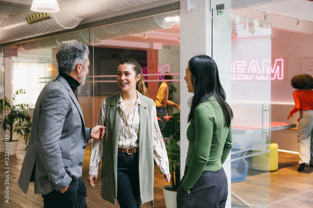 © VICTOR TORRES/Stocksy - Professional colleagues engaged in a lively office conversation