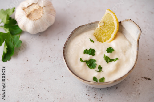 Lebanese Garlic sauce Toum or Salsat toum contains garlic, salt, olive oil and lemon juice. Traditional Middle East food. Food photography.