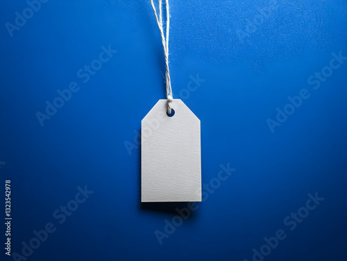 Blank textured paper tag with string on vibrant blue background for branding design