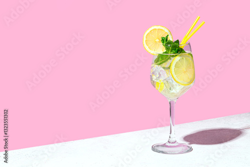 Trendy Hugo Spritz cocktail drink with lemon, mint leaves and ice
