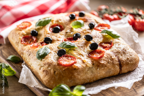 Obraz na płótnie Focaccia - Italian Bread with tomatoes basil leaves olives and olive oil on cutting board w salonie