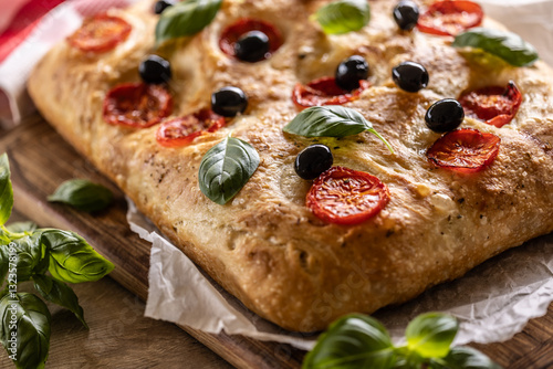 Obraz na płótnie Focaccia - Italian Bread with tomatoes basil leaves olives and olive oil on cutting board w salonie