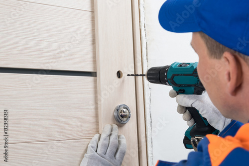The master drills holes to install the door handle photo