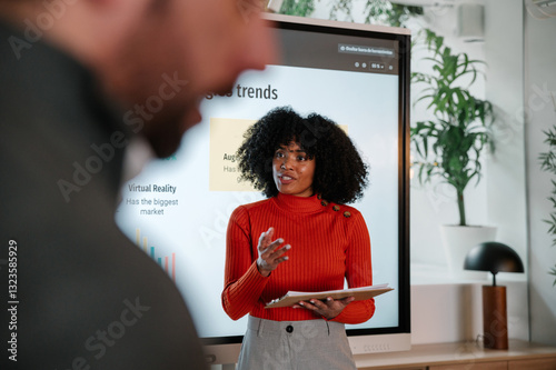Woman Presenting Data Insights on Digital Trends in Meeting