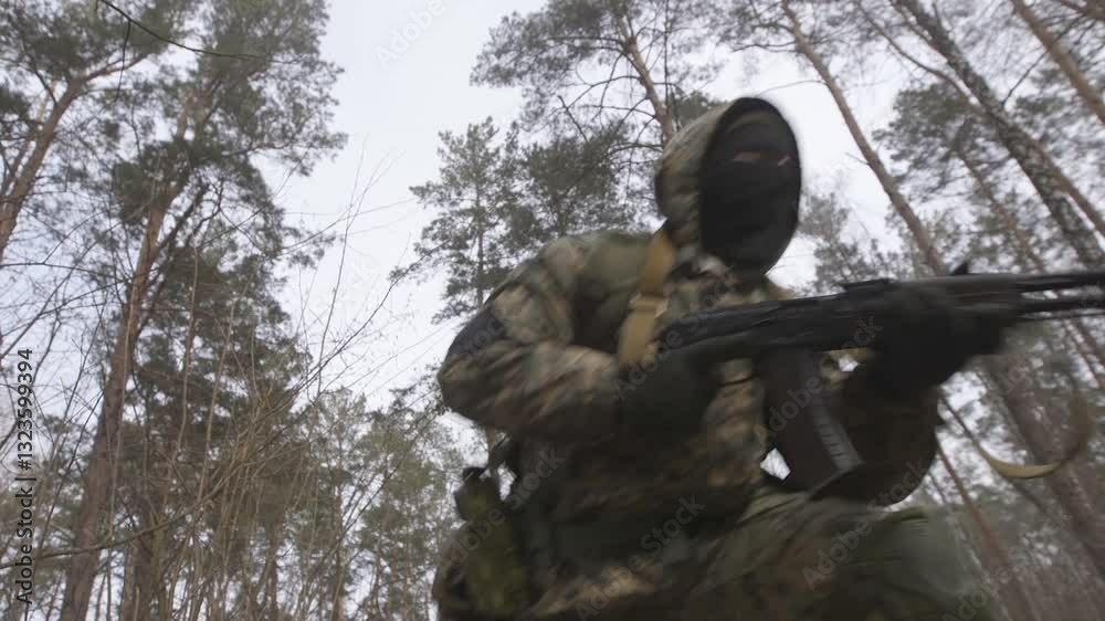 Soldiers in Snow Covered Terrain Training for Cold Weather Military Maneuvers. Equipped military unit used in camouflage on military reconnaissance missions. Rifle in shooting position in dense forest