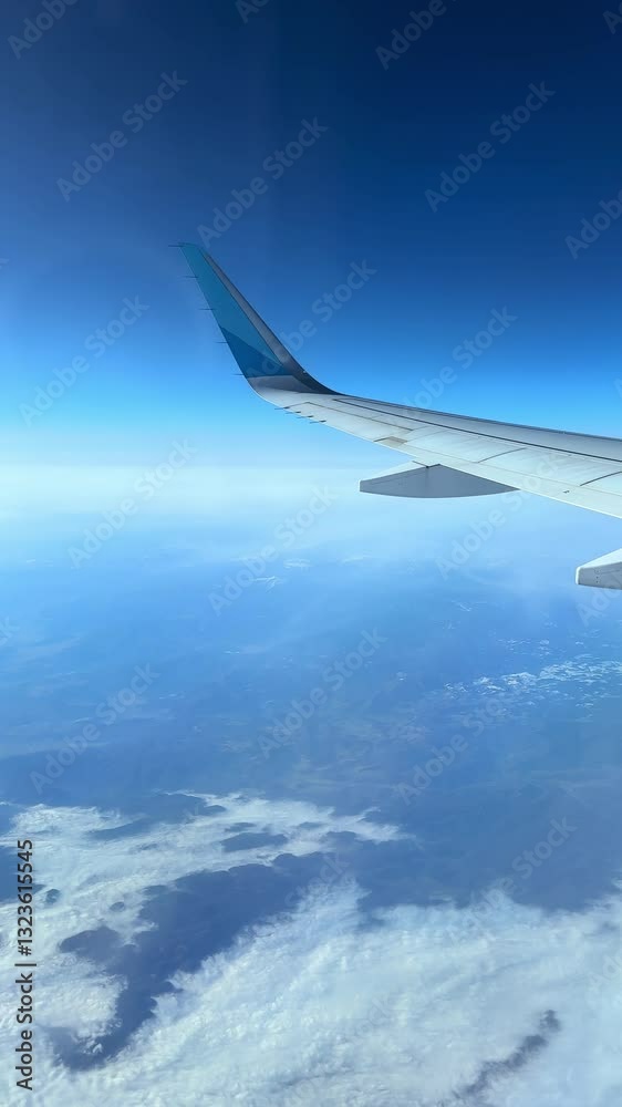 4K vertical video capturing the view from an airplane window with the wing and clouds in the foreground. Filmed at 60fps, showcasing the breathtaking aerial landscape during flight. 4K vertical video capturing the view from an airplane window with the wing and clouds in the foreground. Filmed at 60fps, showcasing the breathtaking aerial landscape during flight.