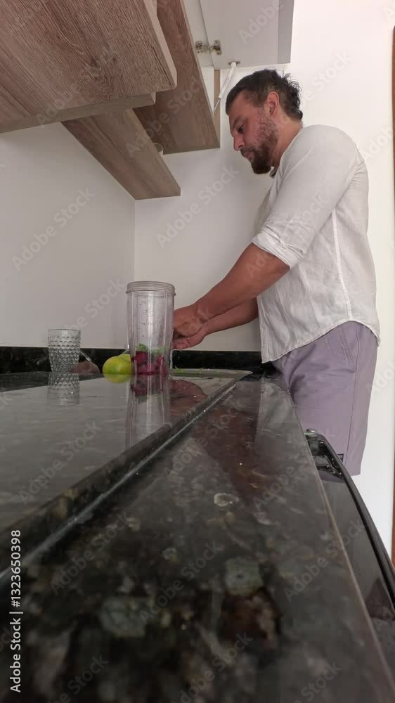 Man alone preparing healthy juice from beetroot, orange, spinach. Man alone preparing healthy juice from beetroot, orange, spinach.