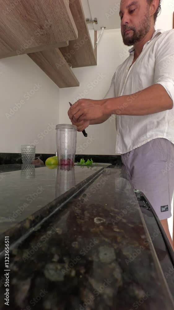 Man alone preparing healthy juice from beetroot, orange, spinach. Man alone preparing healthy juice from beetroot, orange, spinach.