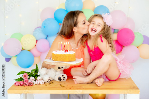 Wall Mural a child's birthday, a mother congratulates her daughter on the holiday, kisses a