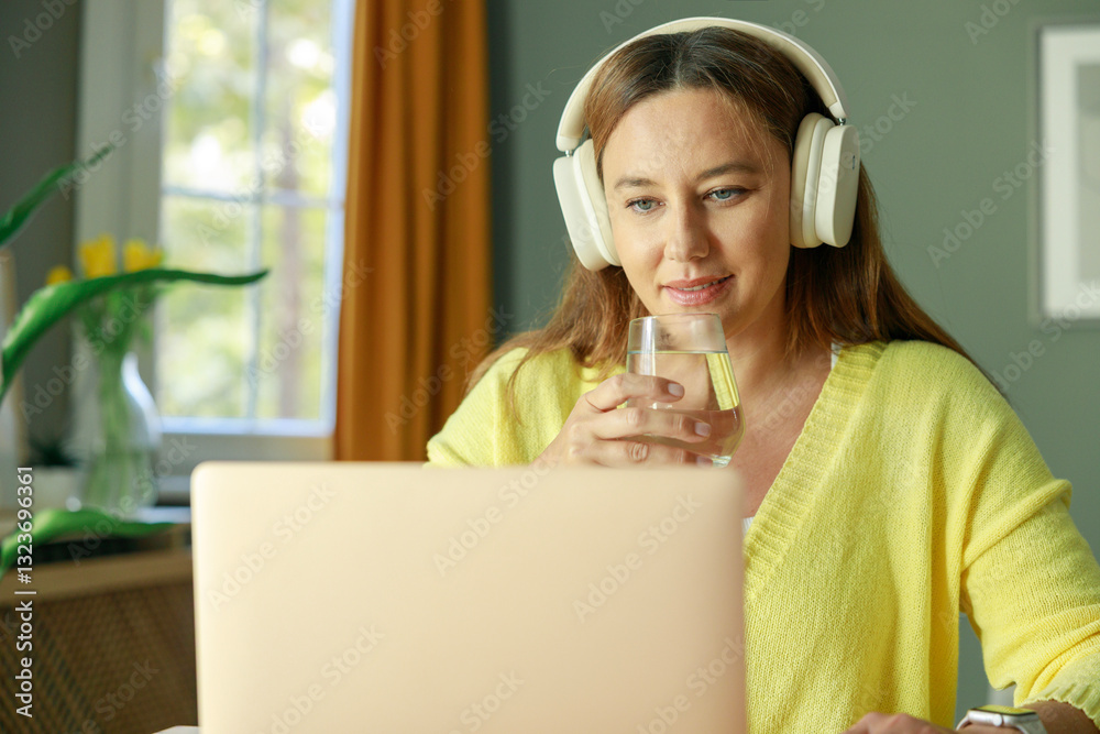 Freelancer young woman working at home and drinking water Freelancer young woman working at home and drinking water