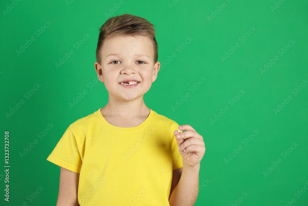 Cute little boy with missing tooth on green background, space for text. Waiting for tooth fairy Cute little boy with missing tooth on green background, space for text. Waiting for tooth fairy