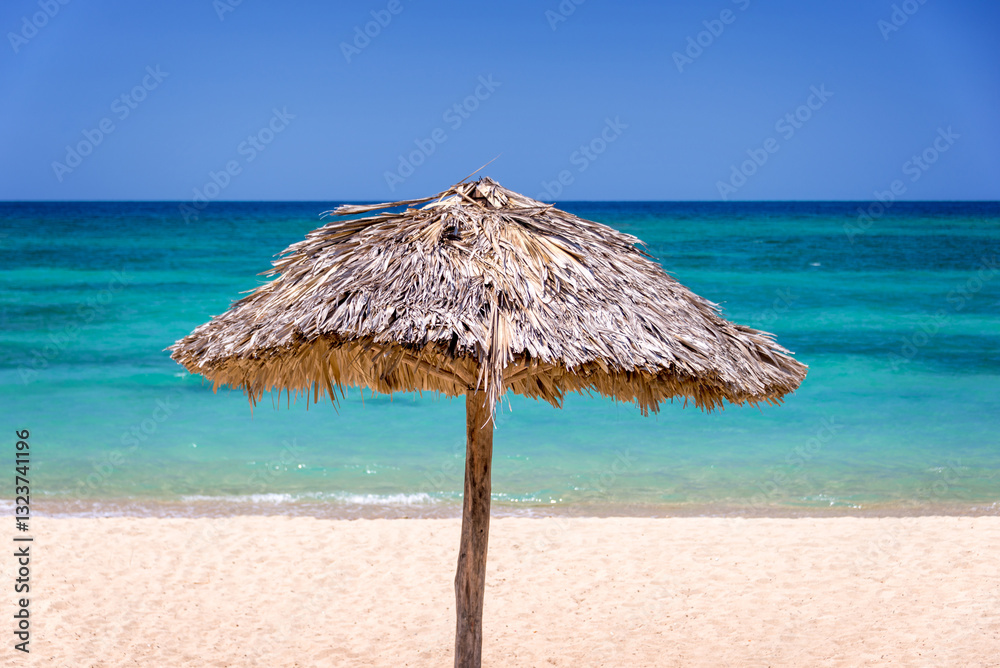 Thatched parasol, sunshade on a beautiful tropical caribbean beach in Cuba