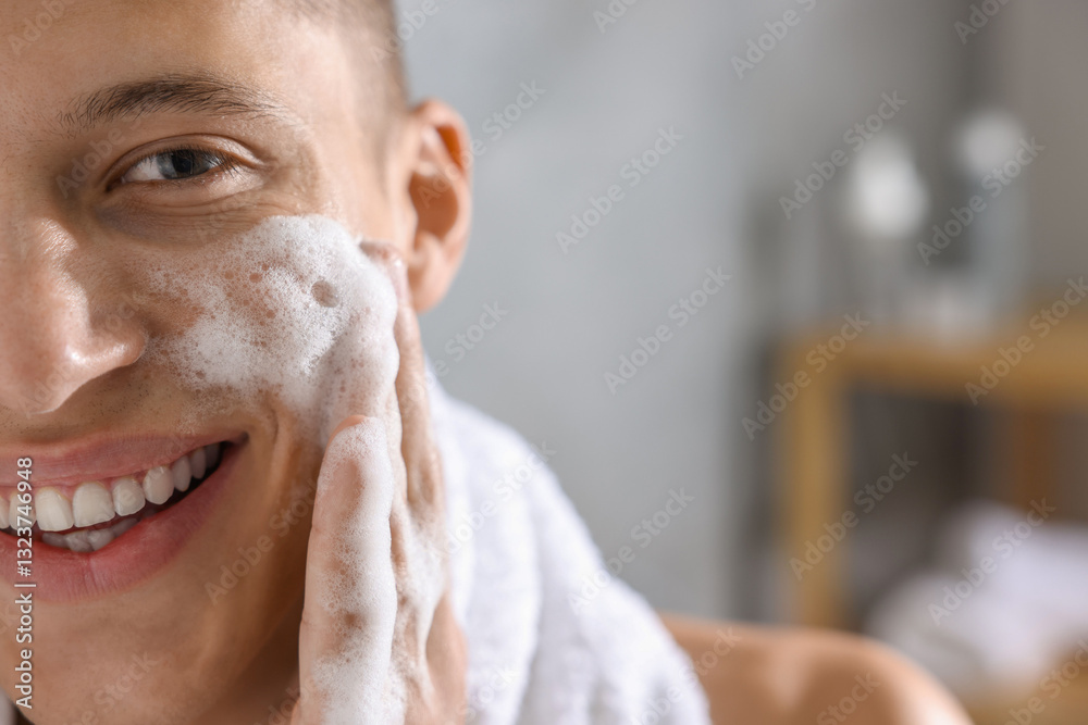 Obraz premium Man washing his face with cosmetic product in bathroom, closeup. Space for text