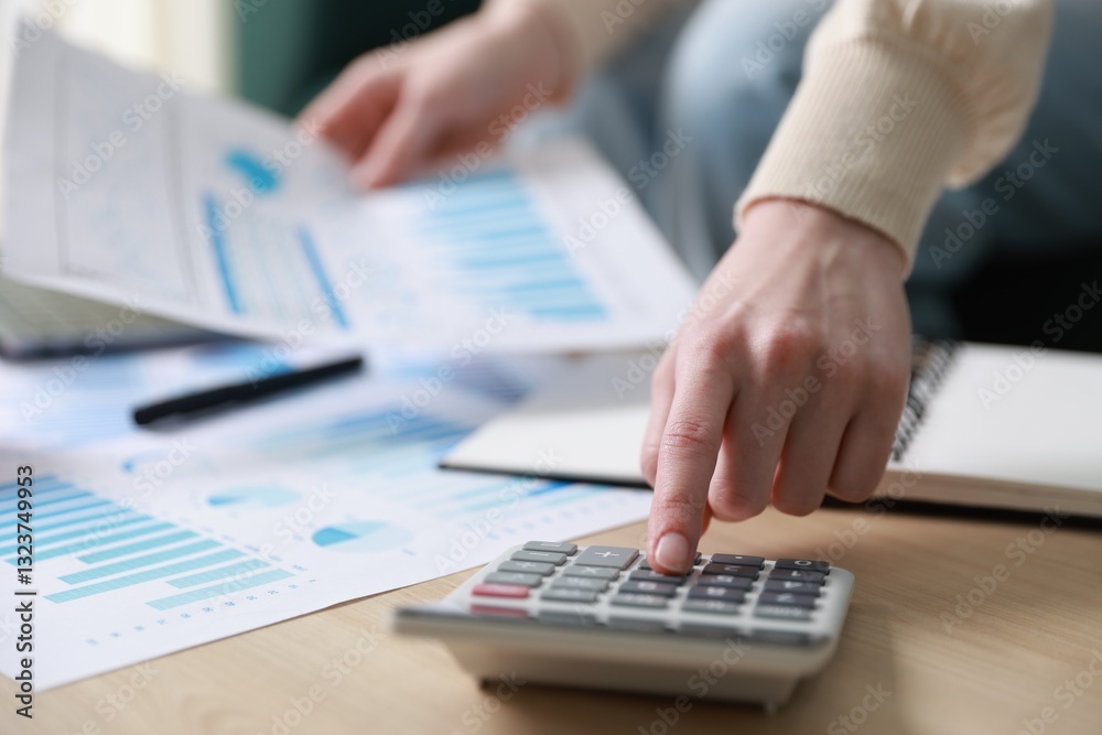 Budget. Woman with paperwork and calculator at wooden desk indoors, closeup Budget. Woman with paperwork and calculator at wooden desk indoors, closeup
