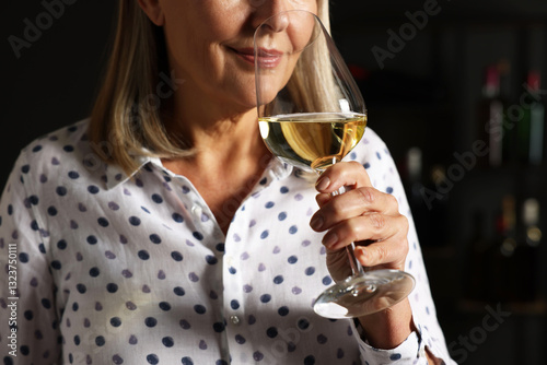 Professional sommelier tasting white wine indoors, closeup
