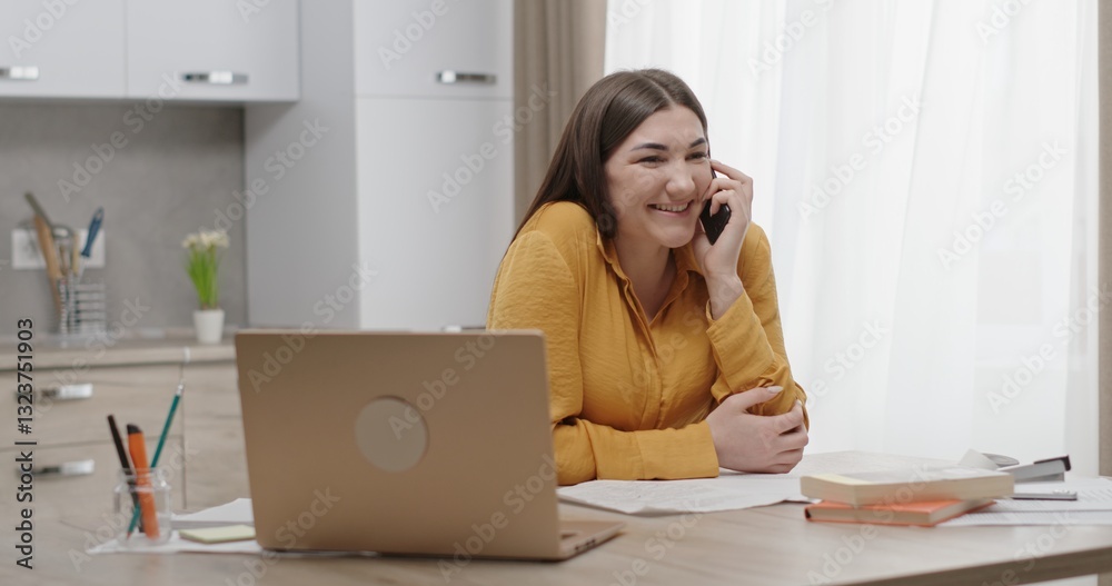 Cheerful woman actively engaged in a lively phone conversation at her cozy home office workspace Cheerful woman actively engaged in a lively phone conversation at her cozy home office workspace