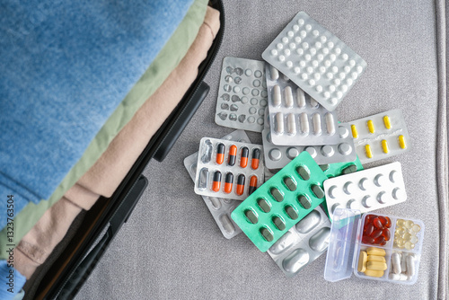 Clothes and pills in a travel bag. Concept of medication required in journey