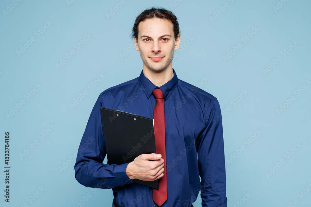 Young rich employee business man corporate lawyer wears classic formal shirt red tie work in office hold clipboard with paper account documents isolated on plain pastel light blue background studio. Young rich employee business man corporate lawyer wears classic formal shirt red tie work in office hold clipboard with paper account documents isolated on plain pastel light blue background studio.
