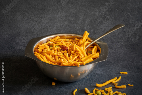 Tableau sur toile Bombay mix in a metal bowl—a popular Indian snack consisting mixture of sev, fried lentils, peanuts, and chickpeas