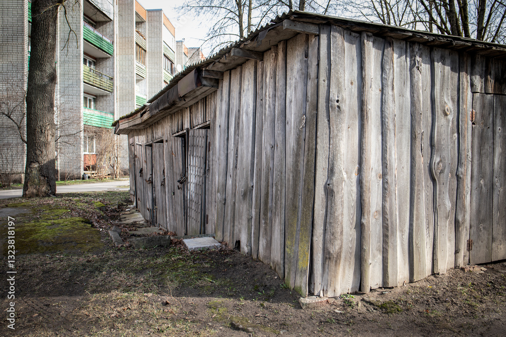 Rustic Wooden Shed with Metal Roof Behind Apartment Building. Rustic Wooden Shed with Metal Roof Behind Apartment Building.
