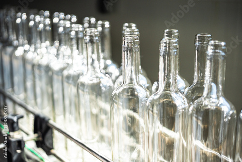 Obraz na płótnie Line of empty glass bottles on a conveyor belt w salonie