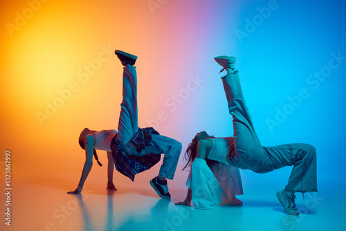 Dynamic image of female dancers moving in sync to hip hop beats against glowing neon gradient background. Concept of modern dance styles, freestyle, breakdance, urban movement, youth culture. photo