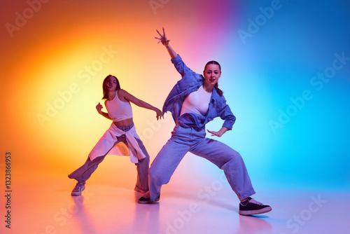 Two hip hop dancers embracing street culture with bold freestyle moves under neon gradient lighting. Concept of rhythm, urban passion, youth energy, contemporary movement, artistic expression.
