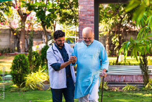 Elderly Indian patient using a walking stick walks with a doctor in a hospital park, discussing health