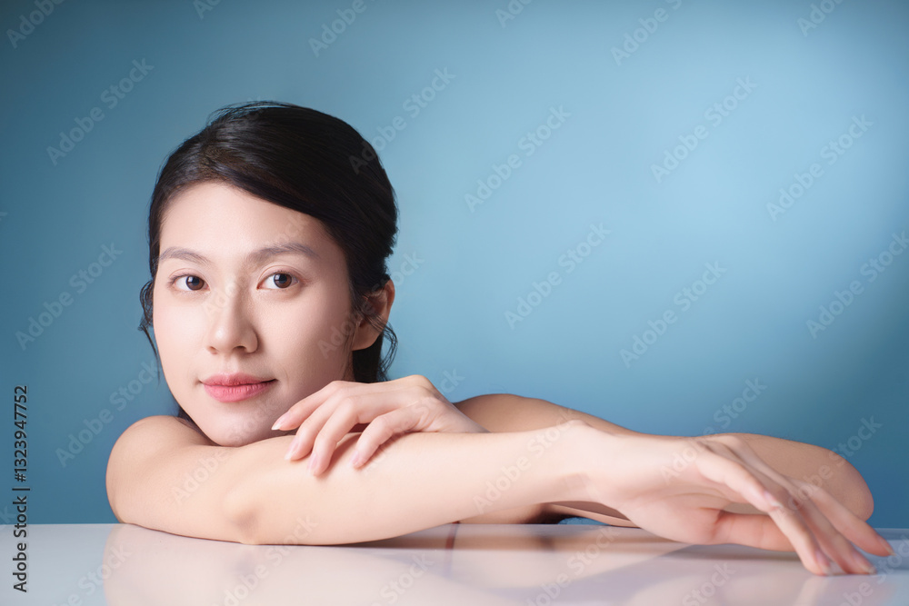 Female portrait with serene expression against a light blue background showcasing natural beauty and calm demeanor Female portrait with serene expression against a light blue background showcasing natural beauty and calm demeanor