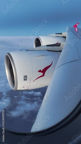 Wing with engines of Airbus A380 Qantas Airlines during flight above the clouds