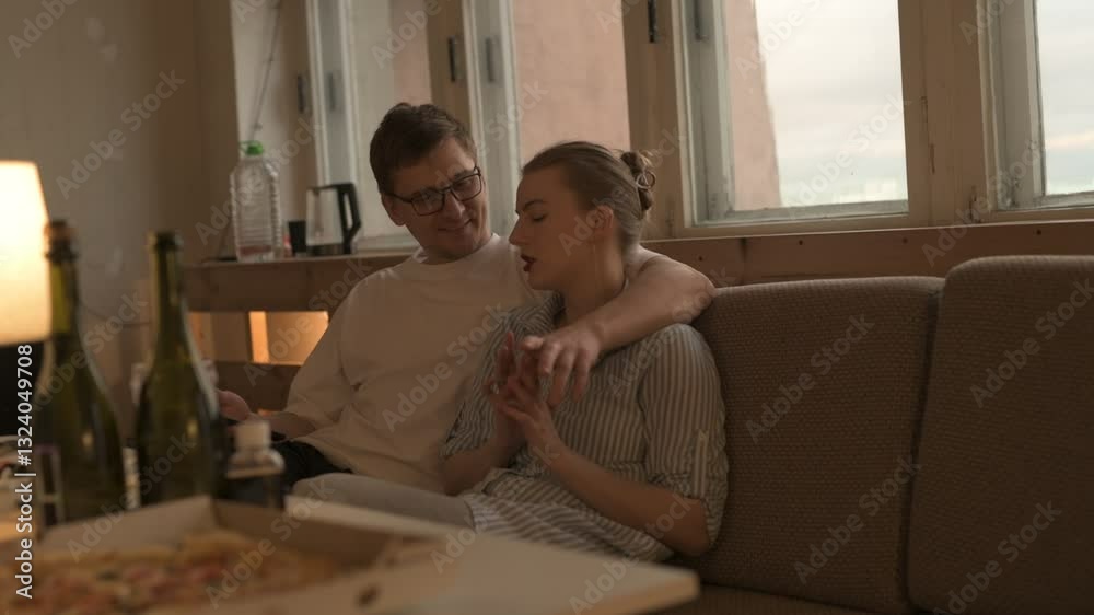 A happy married couple celebrates a holiday: drinking champagne, having dinner, having fun and talking A happy married couple celebrates a holiday: drinking champagne, having dinner, having fun and talking