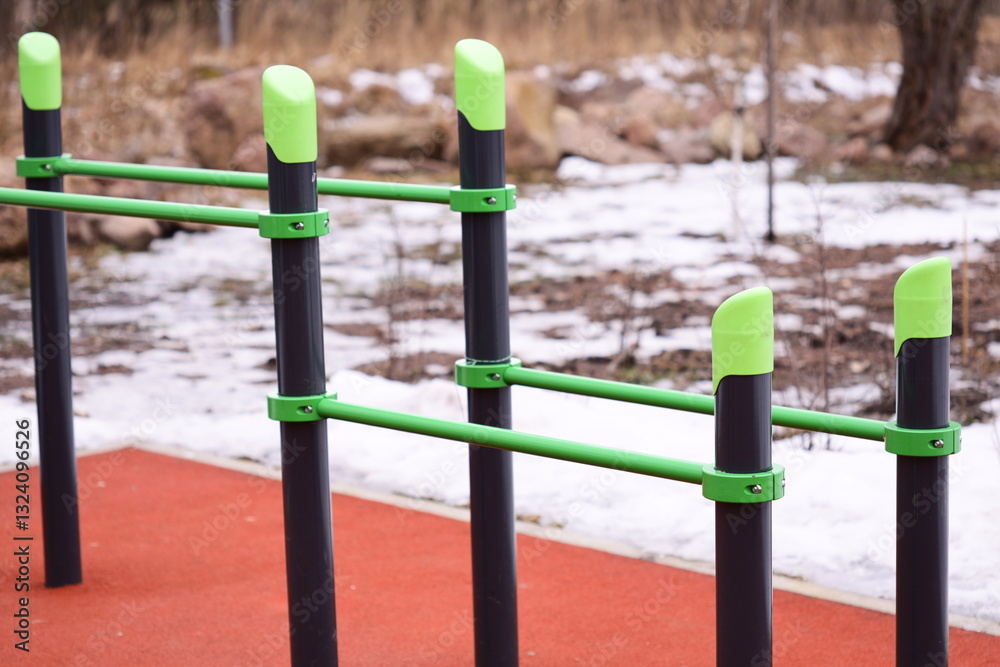 Fototapeta premium Row of green and black poles sit on top of snowy ground, great for winter or outdoor scenes.
