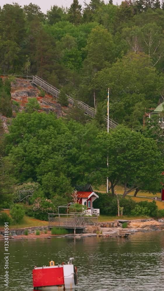 Many Red Swedish Wooden Sauna Logs Cabins Houses On Island Coast In Summer Cloudy Day. Swedish Old Tradition Wooden Houses. Bold Colors. Travel to Sweden