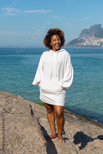 Portrait of a confident young woman in white blouse with blue sea view on the background. 