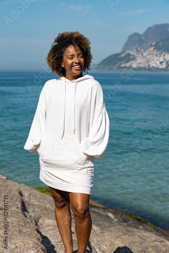 Portrait of a confident young woman in white blouse with blue sea view on the background. 