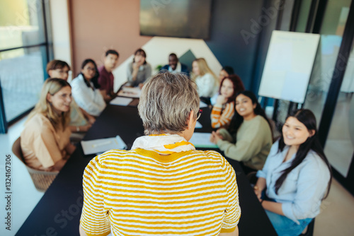 Small class in a modern learning environment with diverse group of students engaged in discussion led by a teacher in a professional setting
