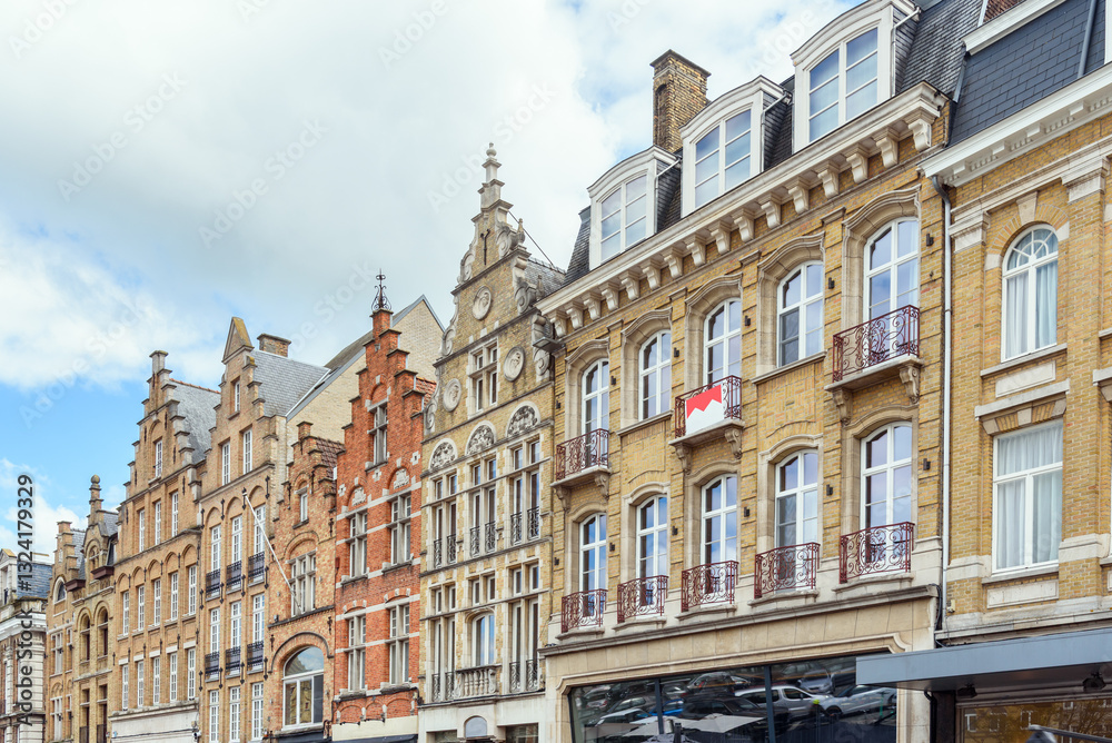 Fototapeta premium Historic residential buildings with shops on ground level in Belgium on a partly cloudy summer day