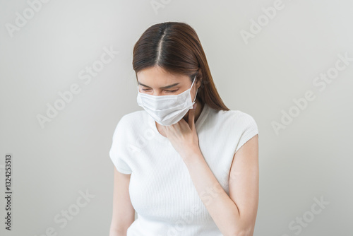 Sickness in inflaming asian young woman, girl use hand check self touch at sore throat, pain thyroid gland on neck or disease reflux, acid of suffer people on wall background. Medical and healthcare.