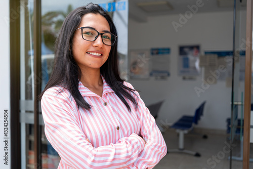 Lifestyle: Hispanic woman with arms crossed smiles proudly at her achievements