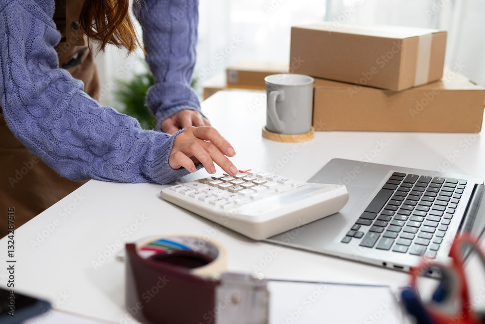 Young woman's hand using calculator on white desk with office equipment Young woman's hand using calculator on white desk with office equipment