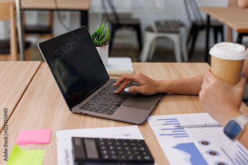 Close up Business Female using calculator and laptop for do math finance on wooden desk, tax, accounting, statistics and analytical research concept	
