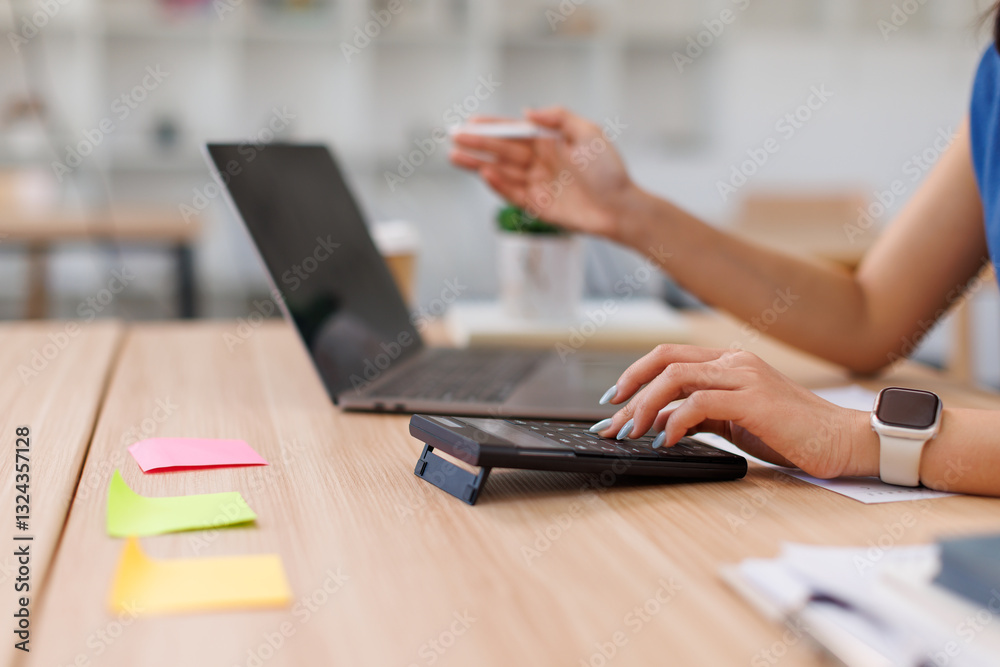 Fototapeta premium Close up Business Female using calculator and laptop for do math finance on wooden desk, tax, accounting, statistics and analytical research concept