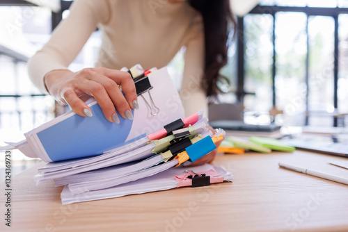 Business Business Documents, woman hands working in Stacks of paper files for searching and checking unfinished document achieves on folders papers
