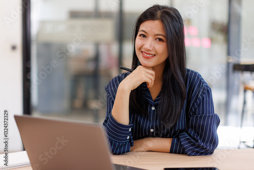 Free Download  Asian businesswoman sits at desk with laptop online using internet and notepad happily recording receipt contact information online delivery.
 - GFXLoad