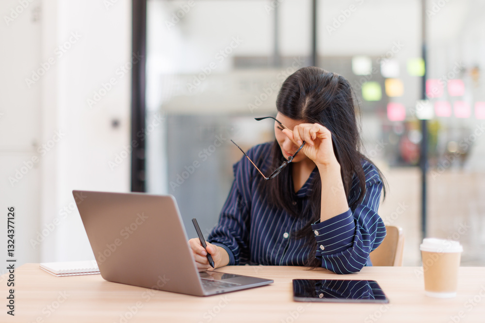 Portrait of tired young business Asian woman work with documents tax laptop computer in office. Sad, unhappy, Worried, Depression, or employee life stress concept Portrait of tired young business Asian woman work with documents tax laptop computer in office. Sad, unhappy, Worried, Depression, or employee life stress concept