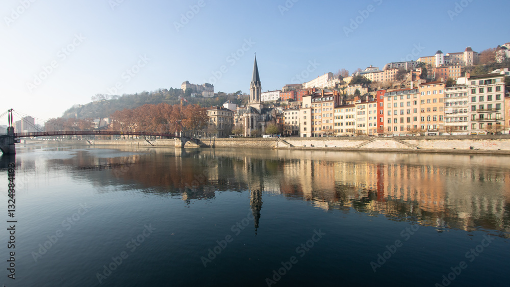 Naklejka premium passerelle rouge piétonne à Lyon au dessus de la Saône reliant la presqu'île au quartier Saint Georges au pied de la colline de Fourvière