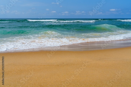 Fototapeta Naklejka Na Ścianę i Meble -  This photo features a stunning sandy beach with golden sand, clear turquoise water, and swaying palm trees under a bright blue sky, making it an ideal tropical paradise for relaxation.